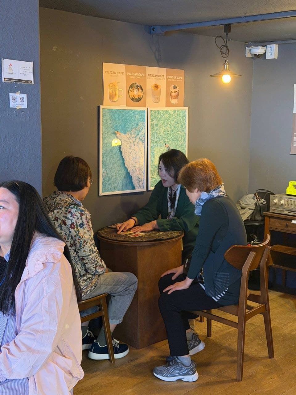 펠리칸 카페에서 테이블에 둘러앉아 타로 카드를 보며 이야기를 나누는 모임